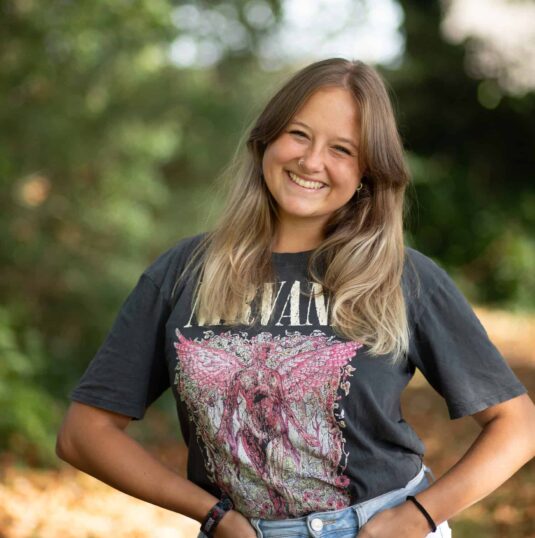 A smiling woman in jeans and a t - shirt.